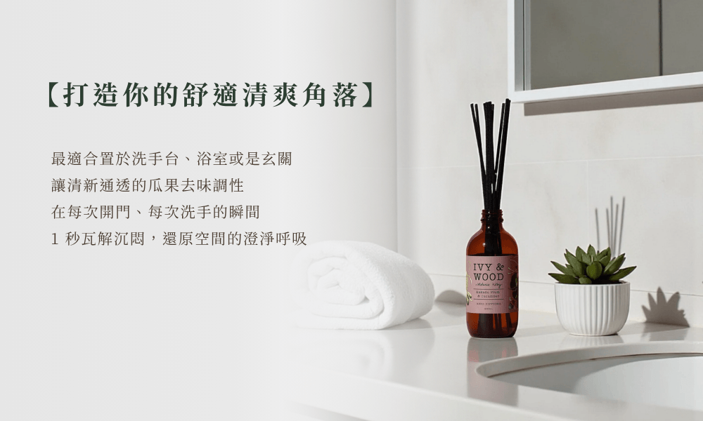 IVY & WOOD 卡卡杜李與青瓜擴香瓶 PDP5 浴室洗手台去異味情境。明亮通透的潔淨浴室內，琥珀擴香瓶置於白色檯面，旁襯多肉盆栽與整齊的白毛巾，搭配左側文案「打造你的舒適清爽角落」，強調小黃瓜瓜果去味調性在每次洗手、開門瞬間 1 秒瓦解空間沉悶與雜味的功能。