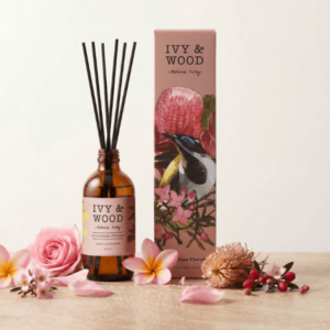 澳洲手工香氛 IVY AND WOOD 花海秘境室內擴香瓶，周圍平鋪擺放飽滿多汁的粉嫩玫瑰花瓣、澳洲雞蛋花與山龍眼，具象表現鮮美嬌嫩的室內香氛